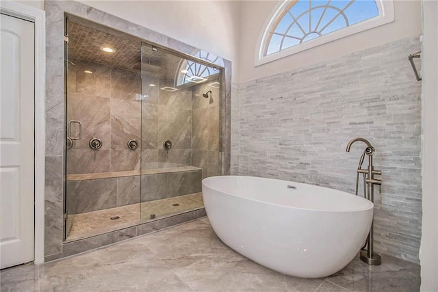 bathroom featuring independent shower and bath and tile walls