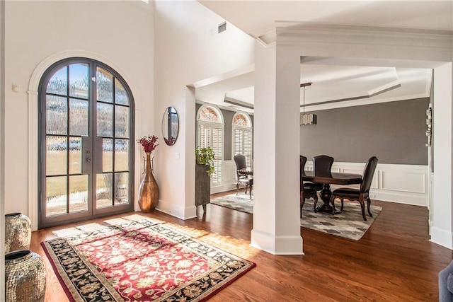 entryway with crown molding, hardwood / wood-style floors, and french doors