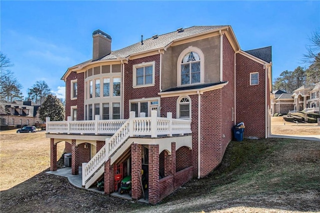 rear view of house featuring cooling unit, a deck, and a lawn