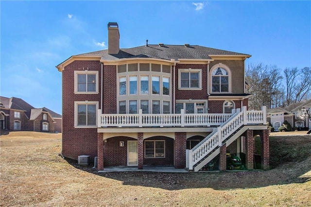 back of property with a wooden deck, a patio, and central air condition unit