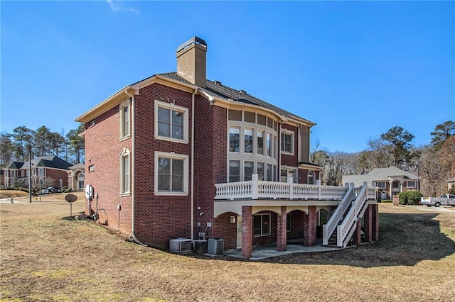 back of house with cooling unit, a lawn, and a deck