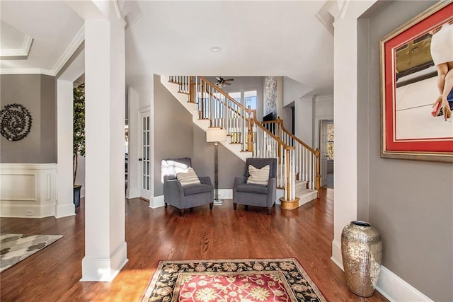 foyer featuring dark hardwood / wood-style flooring, ornamental molding, and decorative columns