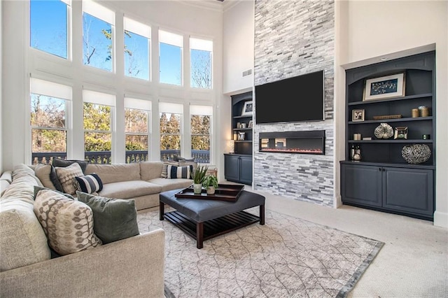 living room with a healthy amount of sunlight, carpet floors, a fireplace, and built in shelves