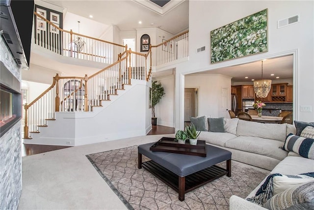 living room with ornamental molding, a high ceiling, and a notable chandelier