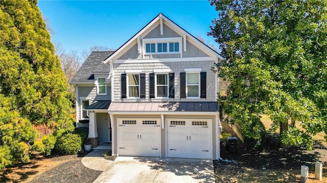 craftsman-style house with a standing seam roof, an attached garage, concrete driveway, board and batten siding, and metal roof