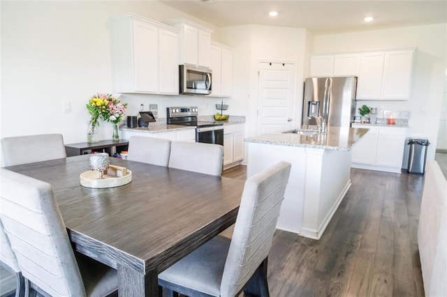 2159 Redfern Rd, Dacula, GA 30019 - kitchen with appliances with stainless steel finishes, a center island with sink, white cabinetry, and recessed lighting