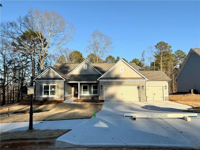 view of front of home with a garage, concrete driveway, and brick siding