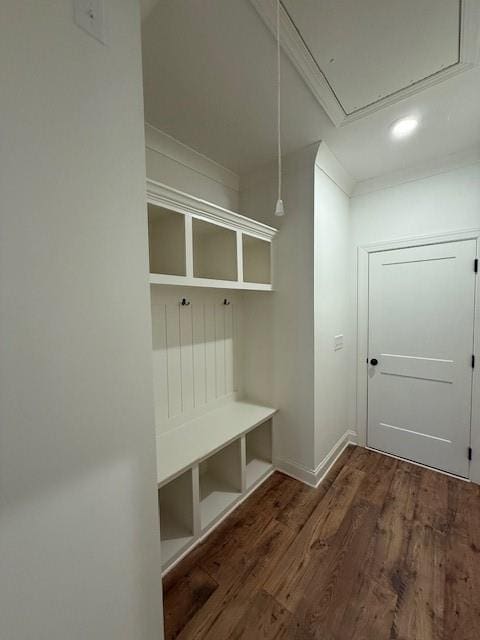 mudroom with attic access, crown molding, and wood finished floors