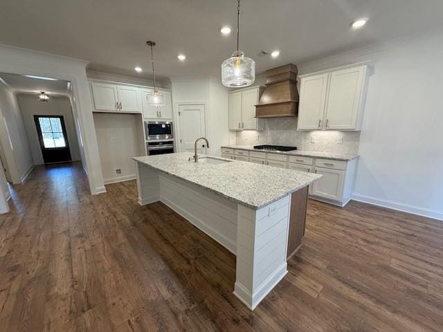 kitchen featuring white cabinets, premium range hood, stainless steel appliances, and decorative backsplash