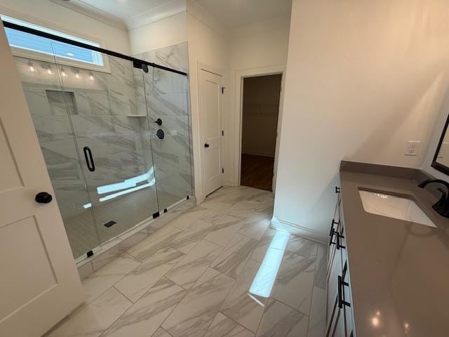 full bath featuring marble finish floor, a marble finish shower, a spacious closet, ornamental molding, and vanity