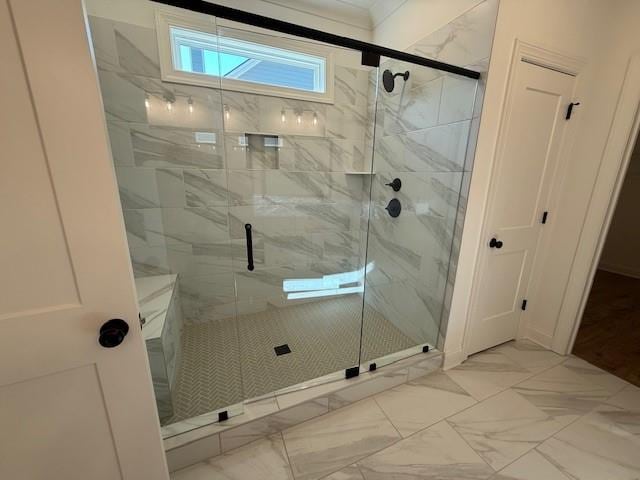 bathroom featuring marble finish floor and a shower stall