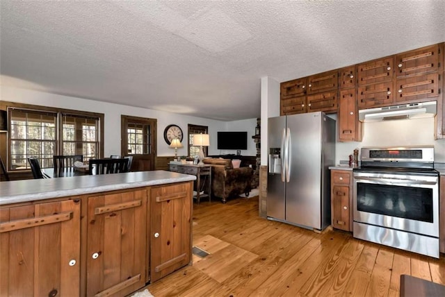 kitchen featuring appliances with stainless steel finishes, light wood-type flooring, and a textured ceiling