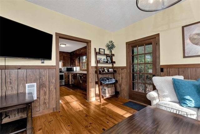 sitting room with wooden walls and light hardwood / wood-style flooring