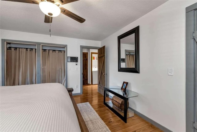 bedroom featuring ceiling fan, wood-type flooring, and a textured ceiling