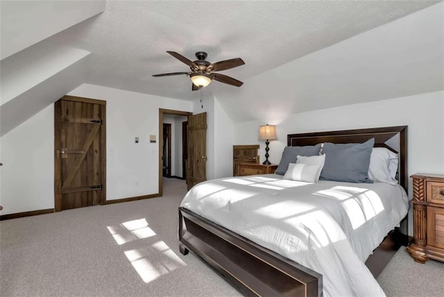 carpeted bedroom with ceiling fan, a textured ceiling, and vaulted ceiling