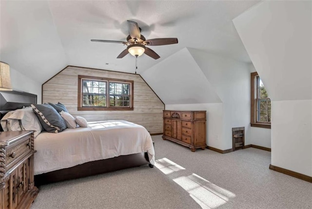 bedroom with multiple windows, light colored carpet, ceiling fan, and wooden walls