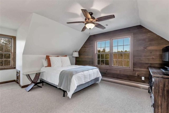 bedroom with light carpet, wooden walls, ceiling fan, and lofted ceiling