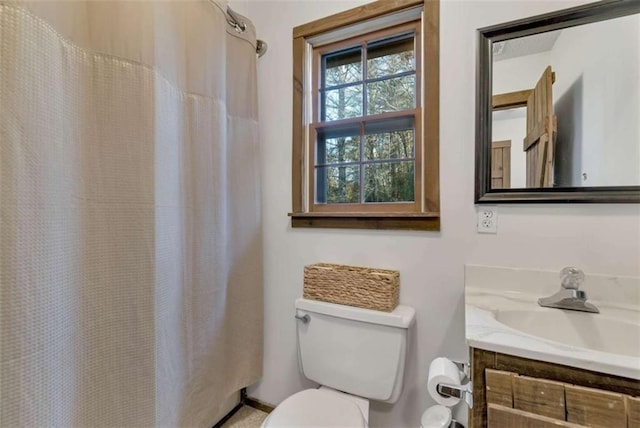 bathroom with vanity, toilet, and walk in shower