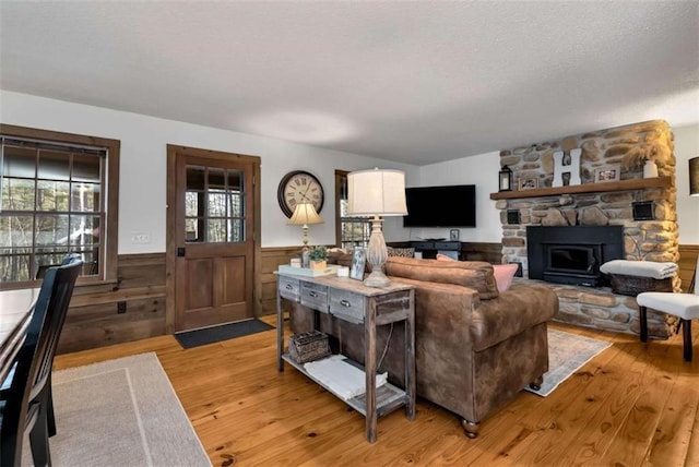 living room with a fireplace, light hardwood / wood-style floors, and a textured ceiling