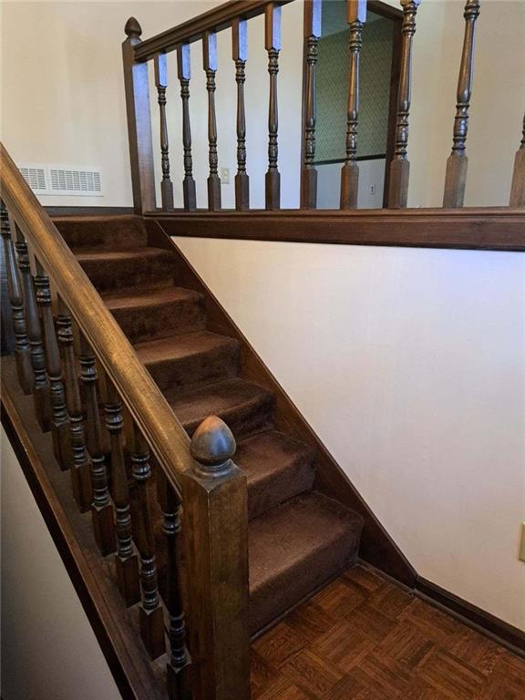 staircase featuring parquet floors