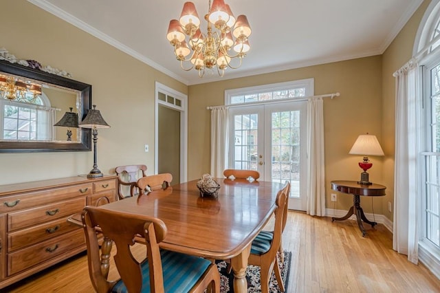 dining space featuring ornamental molding, french doors, light wood-style floors, and baseboards