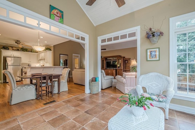 dining area featuring lofted ceiling, a healthy amount of sunlight, ceiling fan, and baseboards