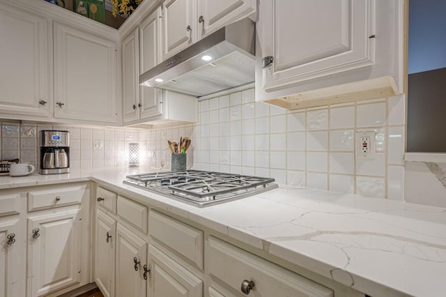 kitchen featuring white cabinetry, under cabinet range hood, tasteful backsplash, and stainless steel gas cooktop