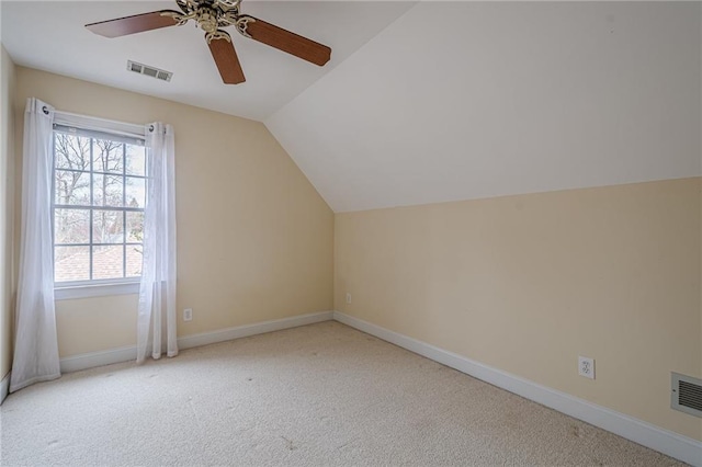 additional living space with carpet floors, visible vents, vaulted ceiling, and baseboards