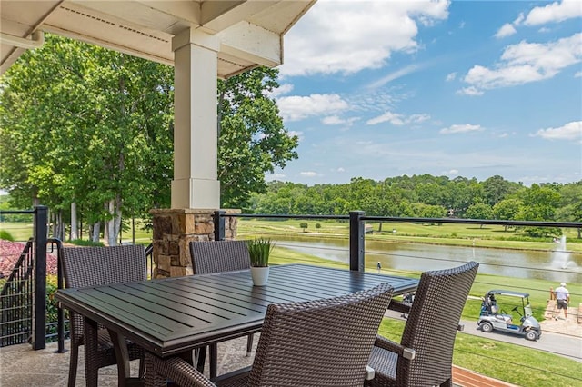 balcony featuring outdoor dining space and a water view