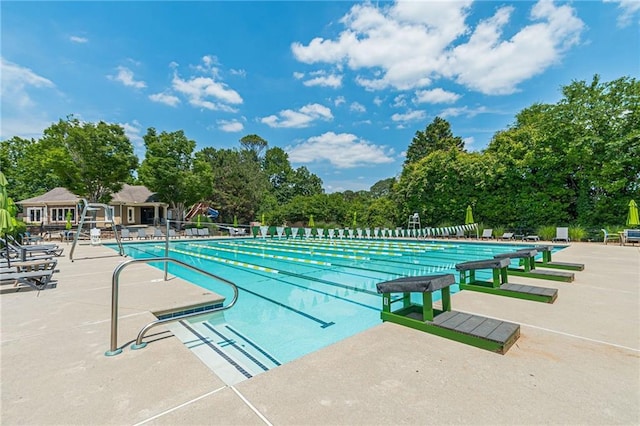 pool with a patio and fence