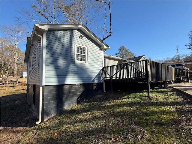 view of property exterior featuring a wooden deck and a yard