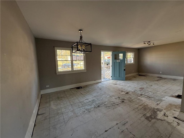 unfurnished dining area featuring a chandelier