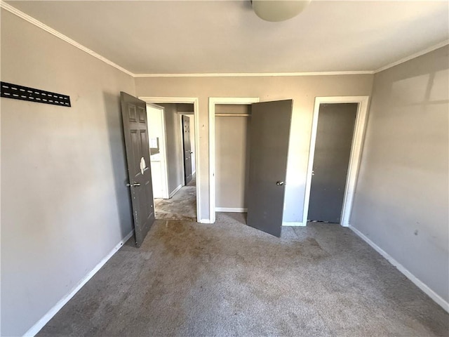 unfurnished bedroom featuring ornamental molding, carpet floors, and two closets