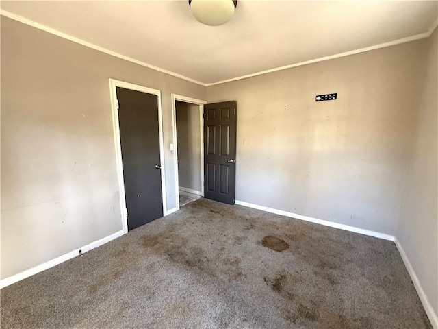 spare room featuring crown molding and carpet