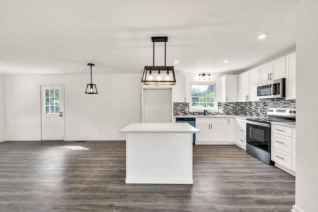716 Phillips Dr, Monroe, GA 30656 - kitchen featuring stainless steel appliances, backsplash, dark wood-style floors, white cabinets, and a center island