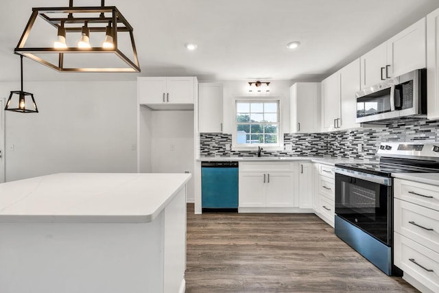 716 Phillips Dr, Monroe, GA 30656 - kitchen featuring stainless steel appliances, a sink, tasteful backsplash, dark wood-type flooring, and white cabinetry