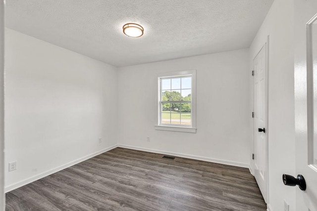 716 Phillips Dr, Monroe, GA 30656 - unfurnished bedroom featuring dark wood finished floors, a textured ceiling, and baseboards