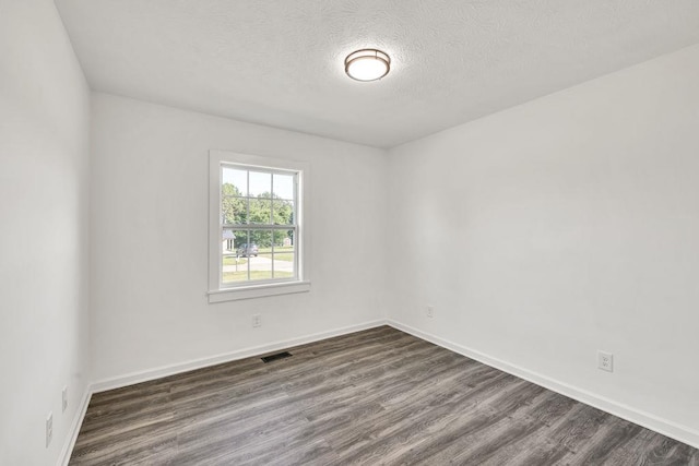 716 Phillips Dr, Monroe, GA 30656 - spare room featuring dark wood finished floors, a textured ceiling, and baseboards