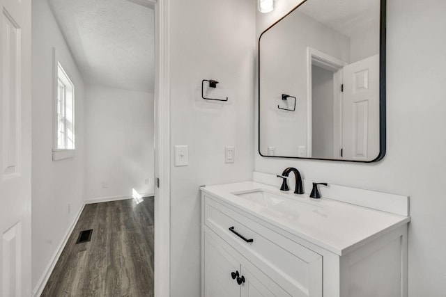 716 Phillips Dr, Monroe, GA 30656 - bathroom with wood finished floors, baseboards, vanity, and a textured ceiling
