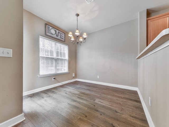 unfurnished dining area with baseboards, dark wood finished floors, and an inviting chandelier