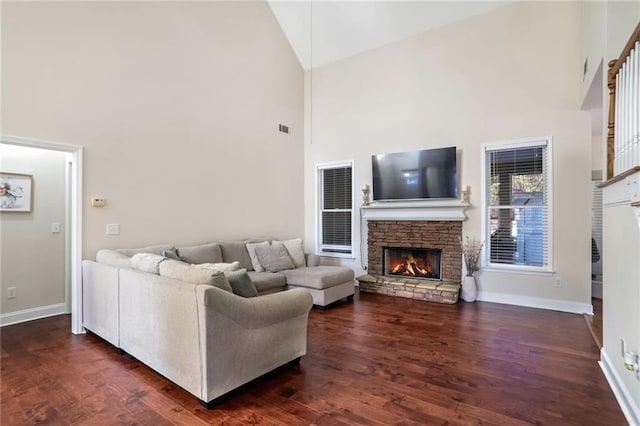 living room with dark hardwood / wood-style floors, high vaulted ceiling, and a fireplace