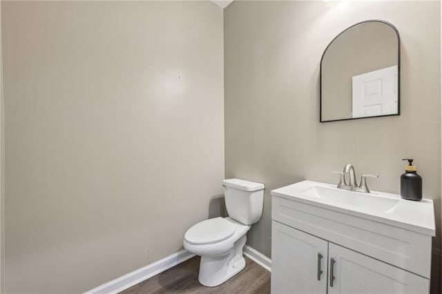7077 Biltmore Trce, Lithonia, GA 30058 - half bathroom with baseboards, wood finished floors, toilet, and vanity