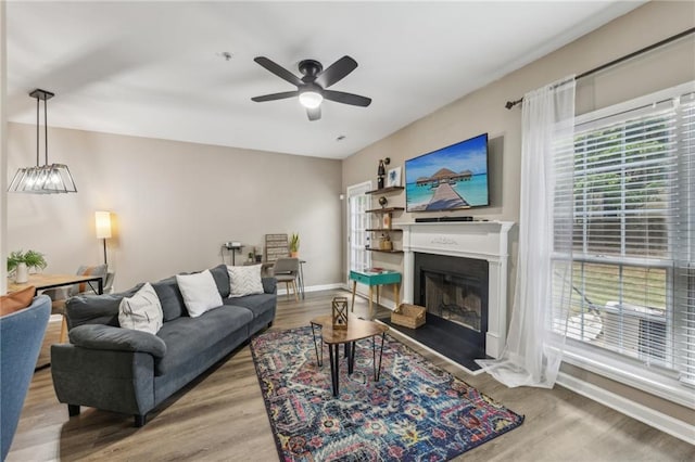 7077 Biltmore Trce, Lithonia, GA 30058 - living area featuring wood finished floors, a ceiling fan, baseboards, and a fireplace with flush hearth