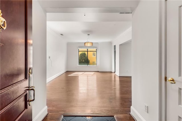 hall with hardwood / wood-style floors and ornamental molding