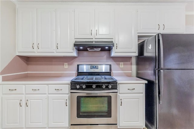 kitchen with black refrigerator, stainless steel range with gas cooktop, ventilation hood, and white cabinets