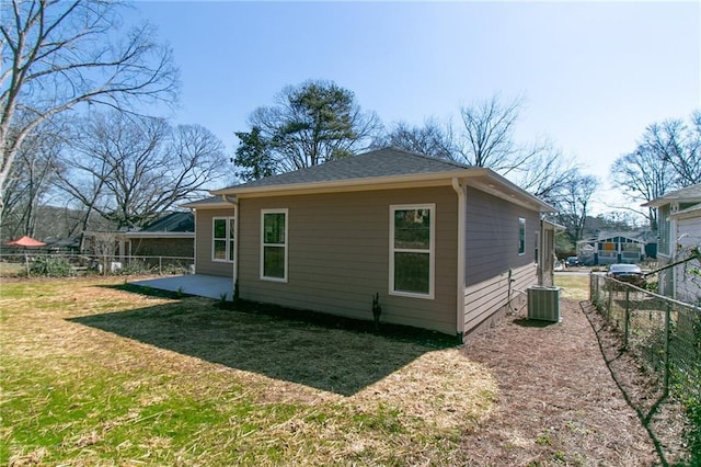 view of home's exterior featuring roof with shingles, a patio, a lawn, fence, and cooling unit