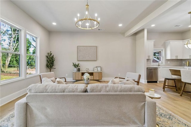 living room featuring a chandelier, recessed lighting, visible vents, baseboards, and light wood-type flooring