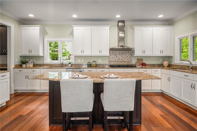 315 Melrose Ave, Decatur, GA 30030 - kitchen with wall chimney exhaust hood, a sink, a breakfast bar area, and white cabinets