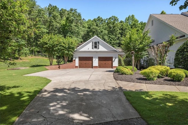 view of front of home with a garage, an outdoor structure, and a front yard