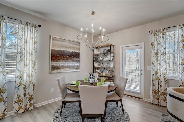 dining space with a chandelier and light hardwood / wood-style floors